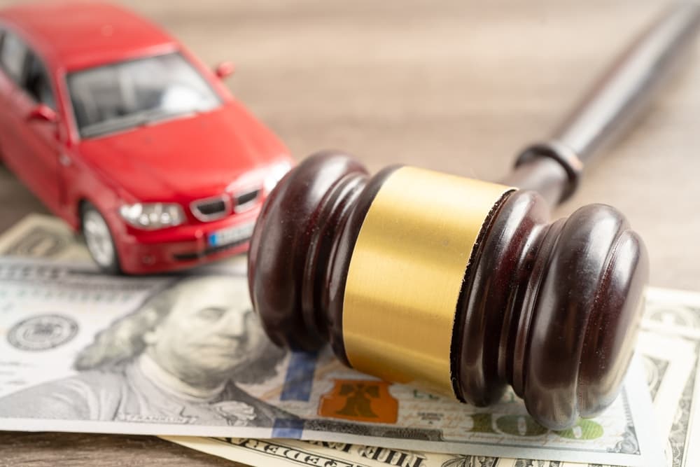 Judge's Gavel with dollar bills and car