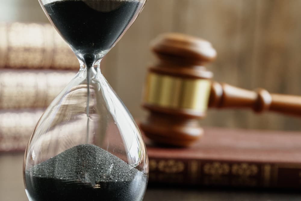 Hourglass and judge gavel on table - Concept of legal timeline