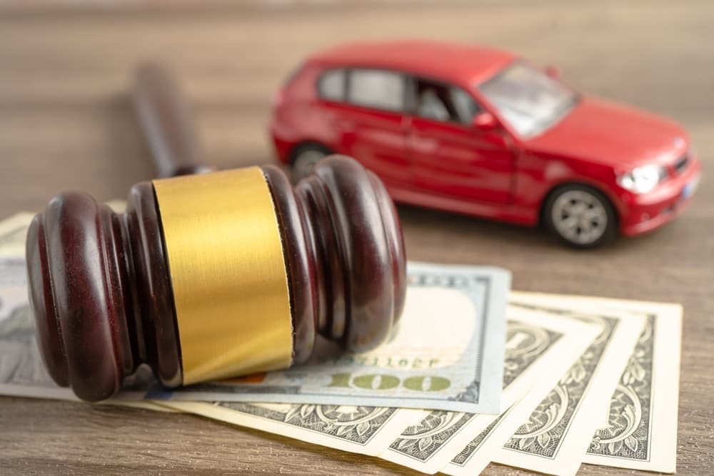 Hammer gavel judge and US dollar banknote money with car vehicle accident,