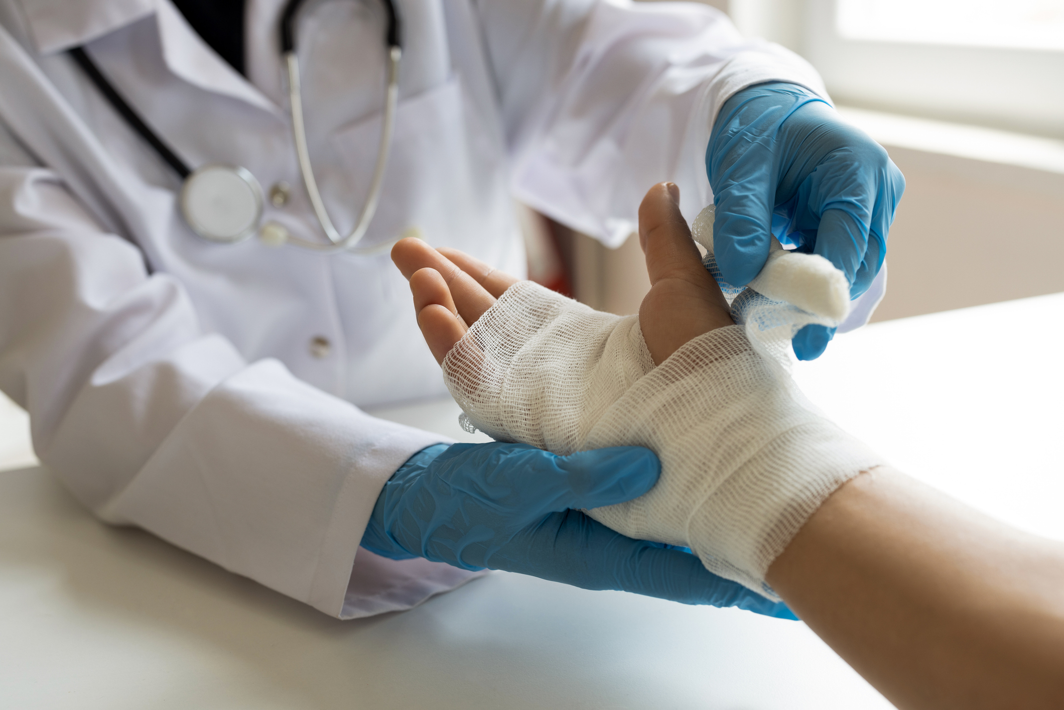 A medical professional bandaging an injured hand