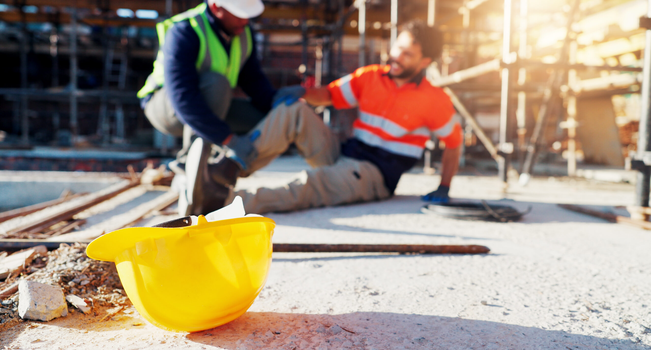 Injured construction worker receiving help after a work-site accident