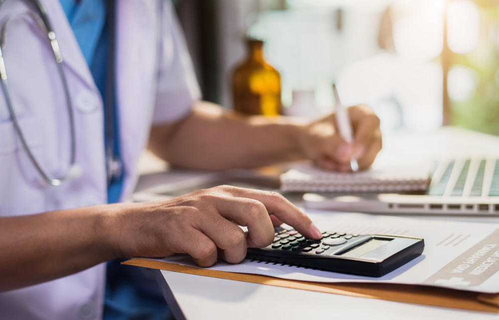 Medical provider calculating treatment costs and expenses