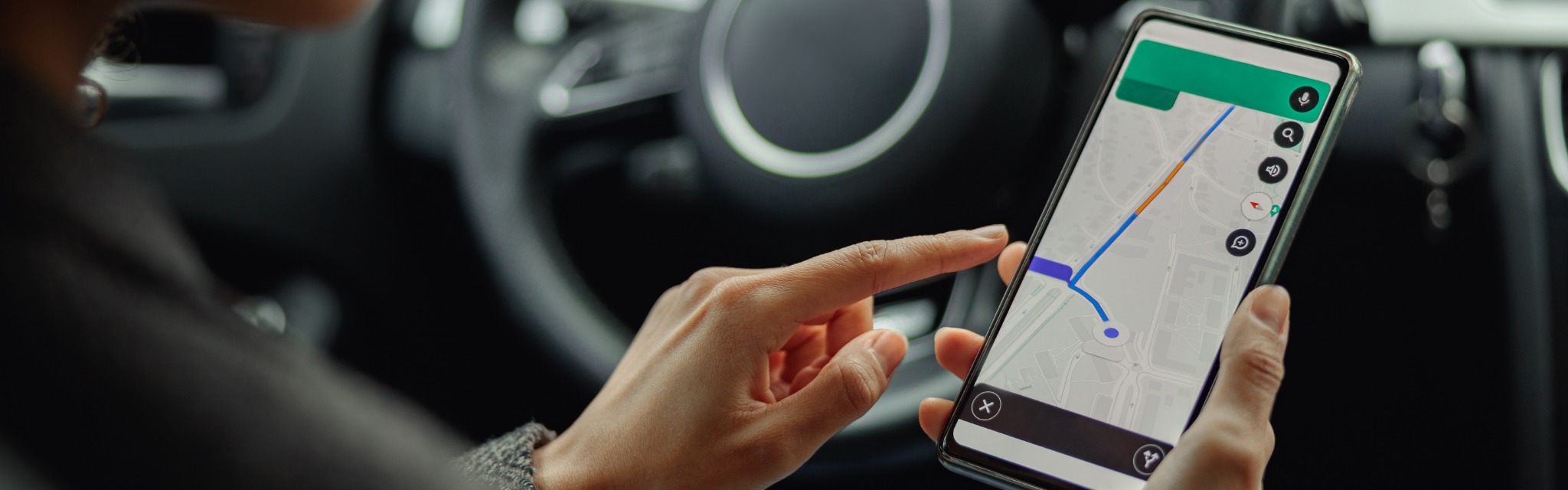 Woman using a navigation app on a smartphone inside a car
